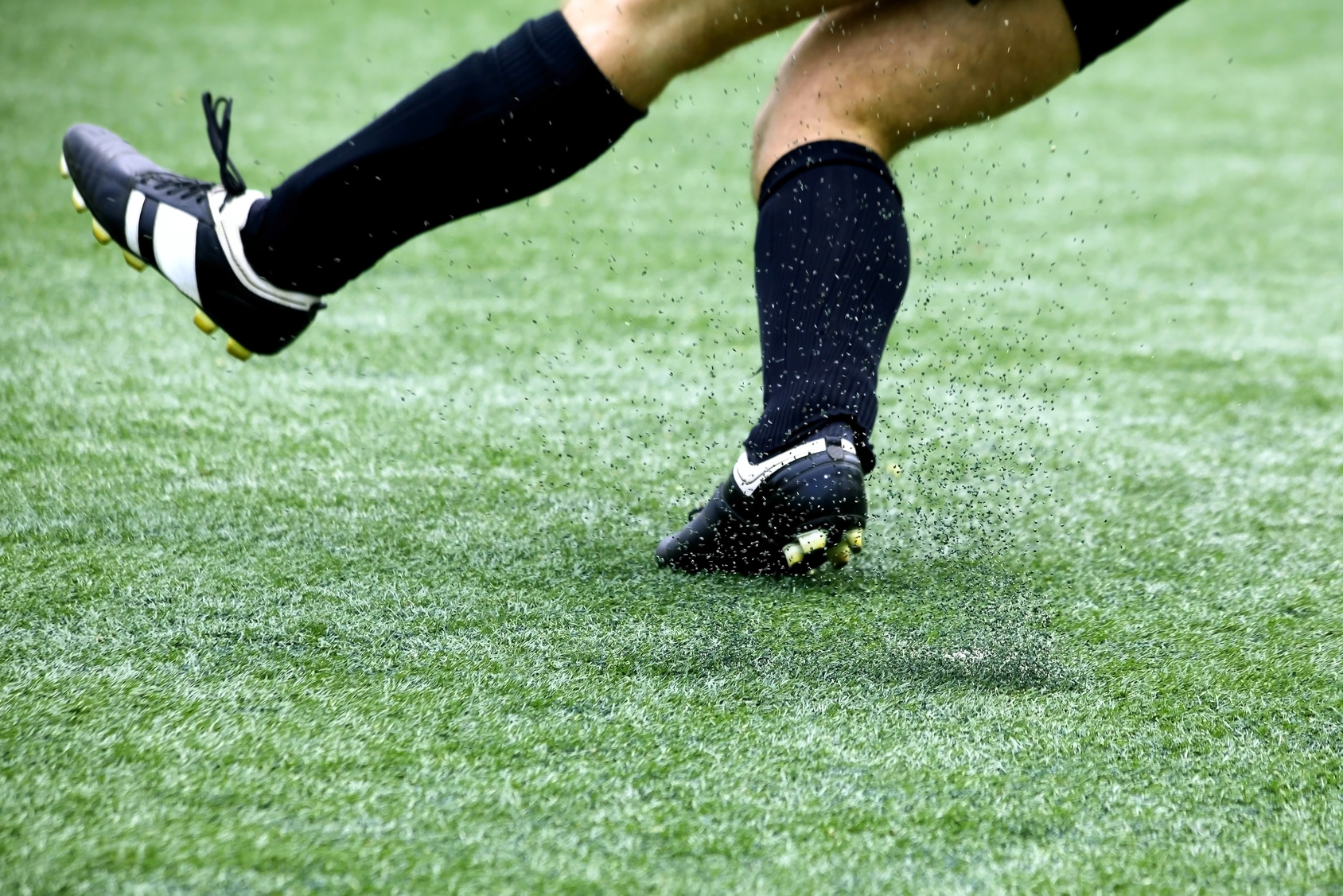 Athlete on synthetic turf, kicking up crumb rubber pellets Image of an athlete on Synthetic Turf, kicking up crumb rubber pellets